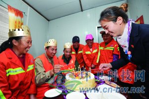 社區(qū)工作人員為集體過生日的三名環(huán)衛(wèi)工人點上生日蠟燭。 本報通訊員 趙松 攝